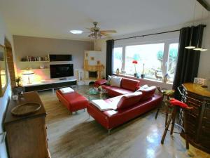 a living room with a red couch and red chairs at Holiday home in Erbach with swimming pool in Dorf Erbach