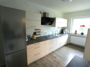 a kitchen with white cabinets and a stainless steel refrigerator at Holiday home in Erbach with swimming pool in Dorf Erbach