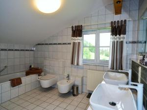 a bathroom with a sink and a tub and a toilet at Holiday apartment with 2 bedrooms in Vorderburg +17 photos