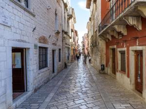 an alley in an old town with people walking down it at Urban Loft Marafor Porec in Poreč