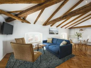 a living room with a blue couch and a table at Urban Loft Marafor Porec in Poreč