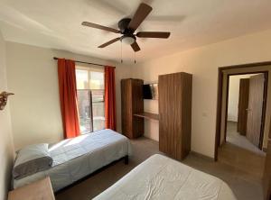 Un dormitorio con dos camas y un ventilador de techo. en La Casaita de Marvellita, en Bandita