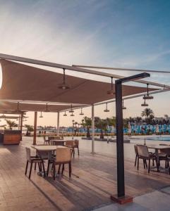 a patio with tables and chairs under a large umbrella at غرفة فندقية in Hurghada