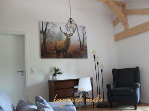 a living room with a picture of a deer on the wall at Your holiday apartment Bavarian more in Gstadt am Chiemsee