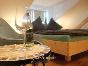 a wine glass sitting on a table next to a bed at Your holiday apartment Bavarian more in Gstadt am Chiemsee