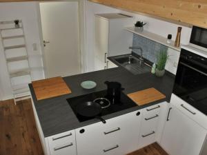 a kitchen with a black counter top with a sink at Your holiday apartment Bavarian more in Gstadt am Chiemsee