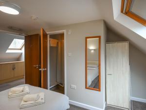 ein Schlafzimmer mit einem Bett mit einem Spiegel und einer Treppe in der Unterkunft The Garden Lodge Flat - Uk49415 in Pembrokeshire + 16 Fotos