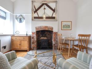 un salon avec une cheminée et une table dans l'établissement Blossom Cottage, à Lydney