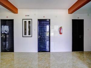 una stanza vuota con due porte e un estintore di Hotel O Gangeshwar ad Ānand