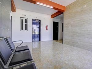 una sala d'attesa con una sedia e una parete di Hotel O Gangeshwar ad Ānand