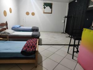 a room with two beds and a table and chairs at Pousada Nova Jerusalém in Cianorte