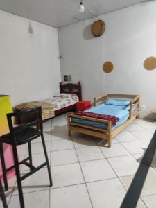 a room with two beds and a chair in it at Pousada Nova Jerusalém in Cianorte +4 photos