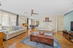a living room with a couch and a tv at Air-conditioned Quiet Stay in Rochedale South in Rochedale South