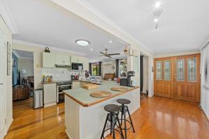 a kitchen with a counter and stools at Air-conditioned Quiet Stay in Rochedale South in Rochedale South +4 photos