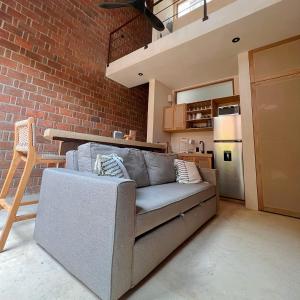 Una sala de estar con un sofá y una pared de ladrillos. en Casa Xaviera, en Puerto Escondido 95 fotos más