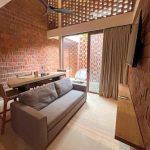 a living room with a couch and a brick wall at Casa Xaviera in Puerto Escondido