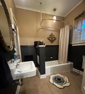 a bathroom with a sink and a mirror and a tub at Opus House Historic Natchitoches in Natchitoches +49 photos