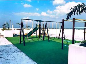 ein Spielplatz mit Rutsche und Schaukel in der Unterkunft The Gray Nest in Naga