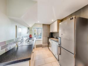 cocina con nevera y lavavajillas en The Granary - Uk48740, en Gaerwen