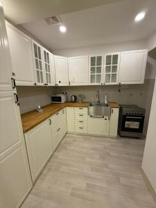 アル・コバールにあるالخبر الشمالية 2の白いキャビネットとシンクのあるキッチン