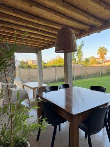 a table and chairs on a patio with a view of a yard at Rincón de Chacras de Coria in Ciudad Lujan de Cuyo