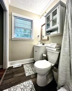 Un baño con inodoro, lavabo y ventana. en Cozy Suite at Songbird Hollow for 1 Guest, en Stone Mountain
