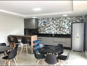een keuken met zwarte stoelen, een tafel en een koelkast bij Casa com 4 quartos com piscina próximo da praia do campeche in Florianópolis