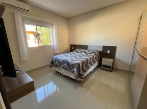een slaapkamer met een bed en een raam bij Casa com 4 quartos com piscina próximo da praia do campeche in Florianópolis