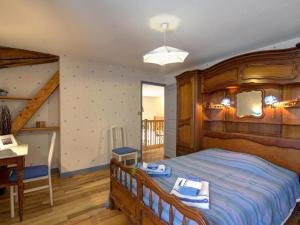 a bedroom with a large wooden bed and a balcony at Gîte paisible avec piscine intérieure et animaux acceptés - FR-1-496-132 in Saint-Priest-la-Prugne +14 photos