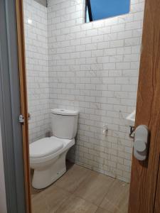 a bathroom with a toilet and a white brick wall at Saya & Awak Tiny House in Kota Bharu +13 photos