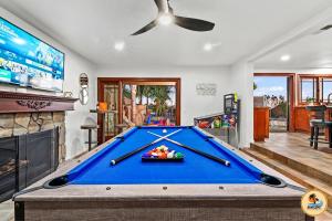 a pool table in a living room with a tv at Slide into Paradise, Pool, Spa & Stunning Views in San Diego