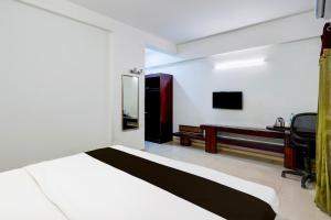 a bedroom with a bed and a desk and a chair at Super Townhouse Medavakkam Near Jayachandran in Chennai