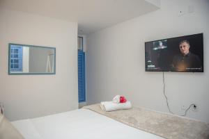ブジオスにあるPousada Vila Capri - Geribáの壁にテレビが付いたベッドのある寝室