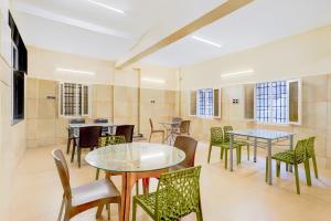 a room with tables and chairs and windows at Super Collection O Vellore Near CMC Hospital Formerly Geetha Residency in Vellore