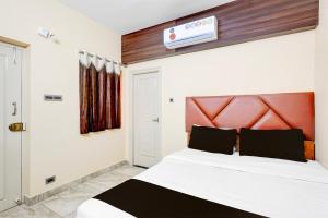 a bedroom with a large white bed with a red headboard at Super Collection O Vellore Near CMC Hospital Formerly Geetha Residency in Vellore