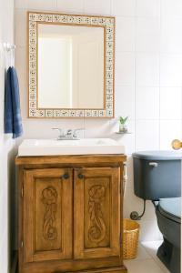 a bathroom with a sink and a mirror and a toilet at Casa de Guijas Tradition Art and Hospitality in Guanajuato