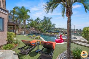 a backyard with a pool with chairs and a palm tree at Slide into Paradise, Pool, Spa & Stunning Views in San Diego +66 photos