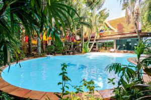 a large swimming pool in a resort with palm trees at Naiharn Pearl Condo Hotel by VillaCarte in Nai Harn Beach +4 photos