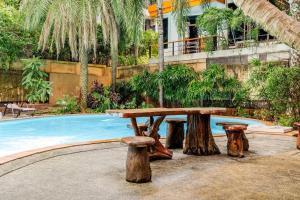 a wooden picnic table next to a swimming pool at Naiharn Pearl Condo Hotel by VillaCarte in Nai Harn Beach