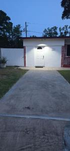 a garage with a white door and a driveway at Araly's house in Tampa