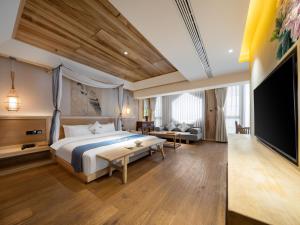 Una habitación de hotel con una cama y un televisor de pantalla plana. en 成都鹪鹩人文精品酒店, en Chengdú