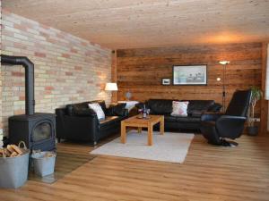 Una sala de estar con muebles de cuero y chimenea. en Holiday Apartment Schwärzler, en Stiefenhofen