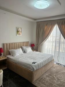 ダカールにあるResidence DIBAの大きなベッドと大きな窓のある寝室