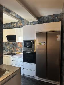 ダカールにあるResidence DIBAのステンレス製の冷蔵庫とコンロを備えたキッチン