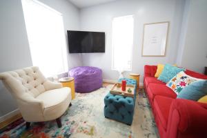 a living room with a red couch and a chair at Luxurious Renovated Gem in Convenient Location! in Delta