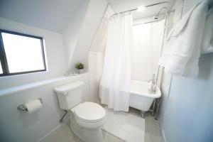 a white bathroom with a toilet and a sink at Luxurious Renovated Gem in Convenient Location! in Delta +48 photos