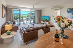 a living room with a couch and a table at Lagoon 004 by HamoRent on Hamilton Island in Hamilton Island