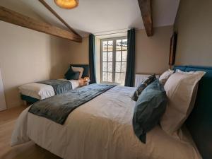a bedroom with two beds and a large window at Charmant gîte avec piscine chauffée et Wi-Fi en pleine nature - FR-1-653-283 in Pranzac +27 photos