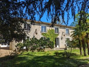 a large stone building with trees in front of it at Grande maison avec piscine privée, wifi et animaux acceptés pour 15 pers. - FR-1-653-282 in Pranzac