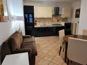 a living room with a couch and a table and a kitchen at Romantic Suite Privèe Oberje in Oulx